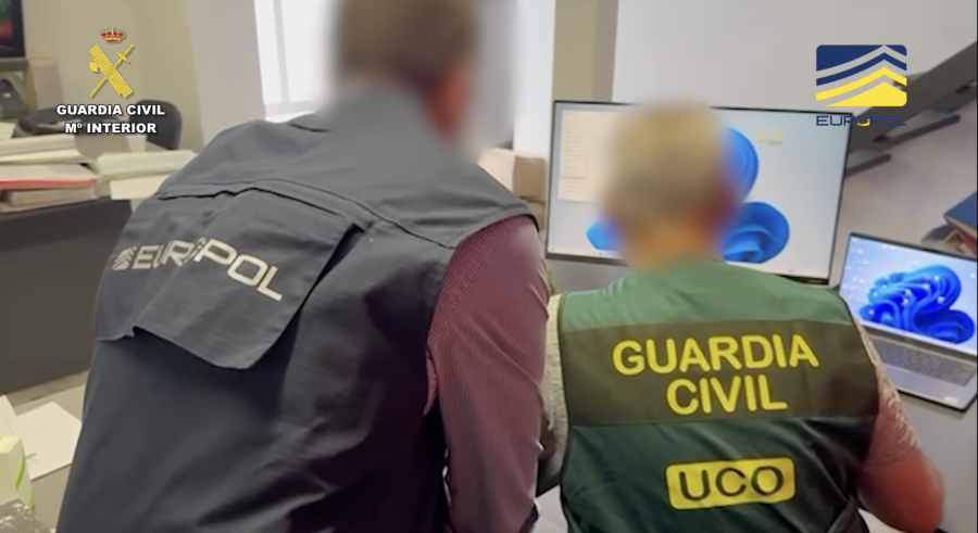 Europol and Guardia Civil officers at computer workstations during the operation against a cryptocurrency investment fraud network