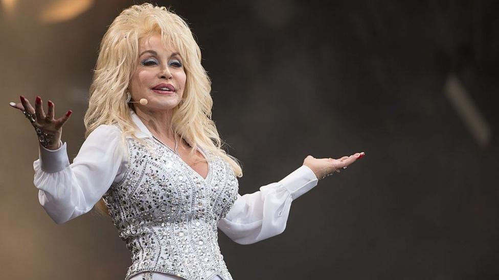 Dolly Parton in a white shirt and embellished waistcoat