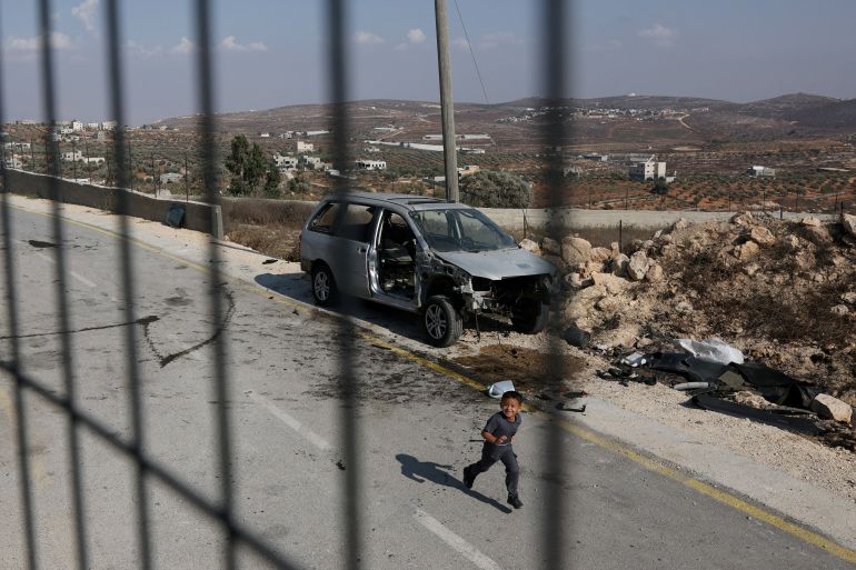 A child playing on a road at the edge of a Palestinian village