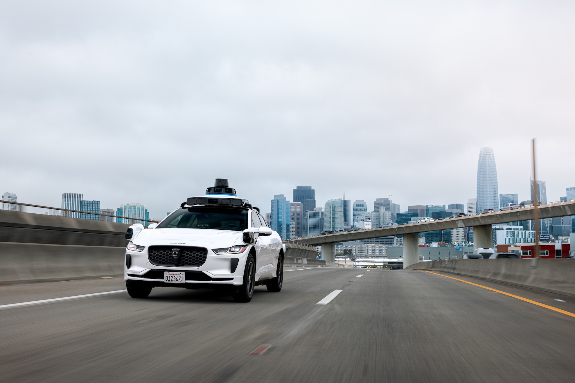 An autonomous vehicle with roof-mounted sensors on a city street