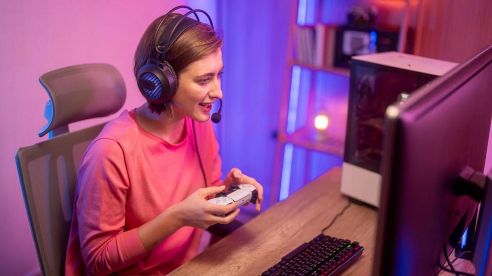 A streamer at a desk with a headset and games controller