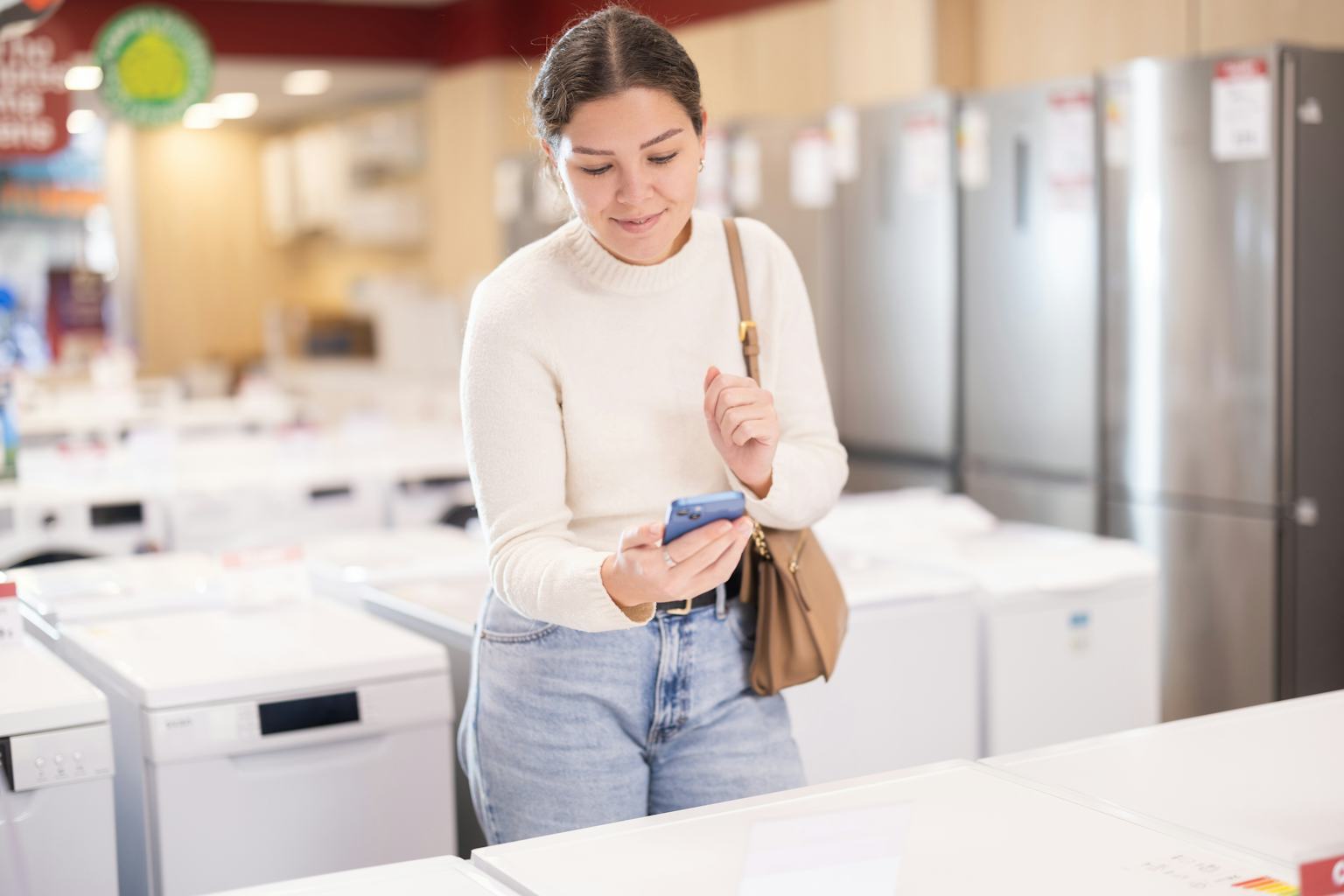 A shopper comparing household appliances in a showroom