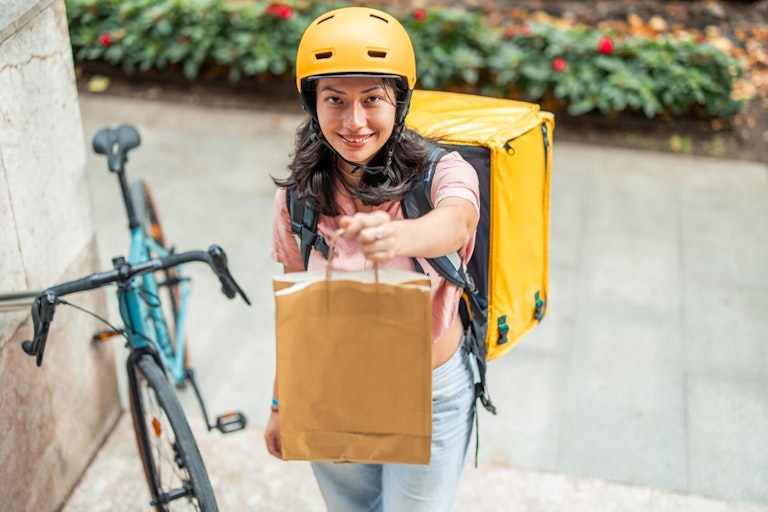 A delivery worker checking a phone while working a shift
