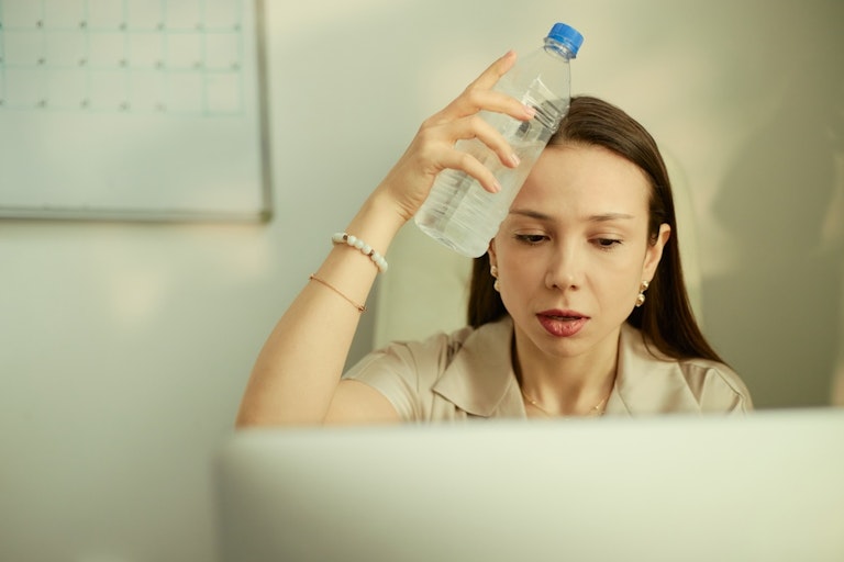 A worker wiping their forehead in high temperatures
